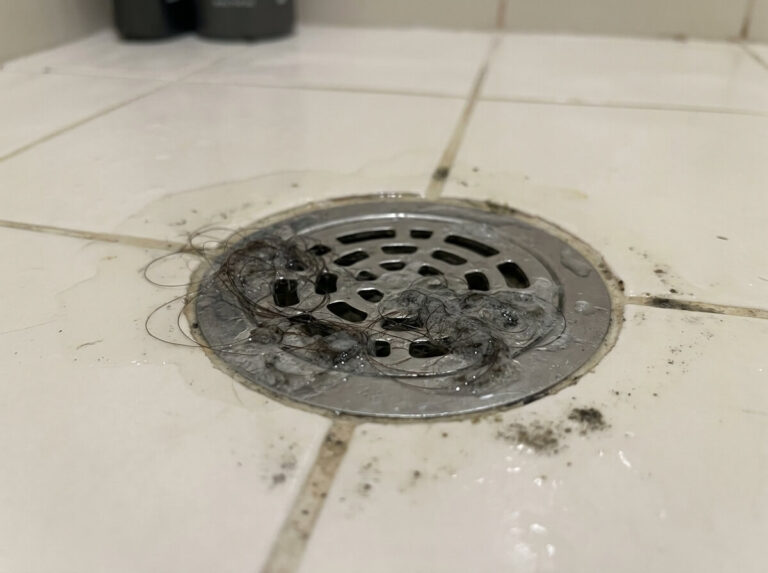 Verstopfter Duschabfluss mit Haaren als typisches Problem fuer Abflussreinigung Dusche